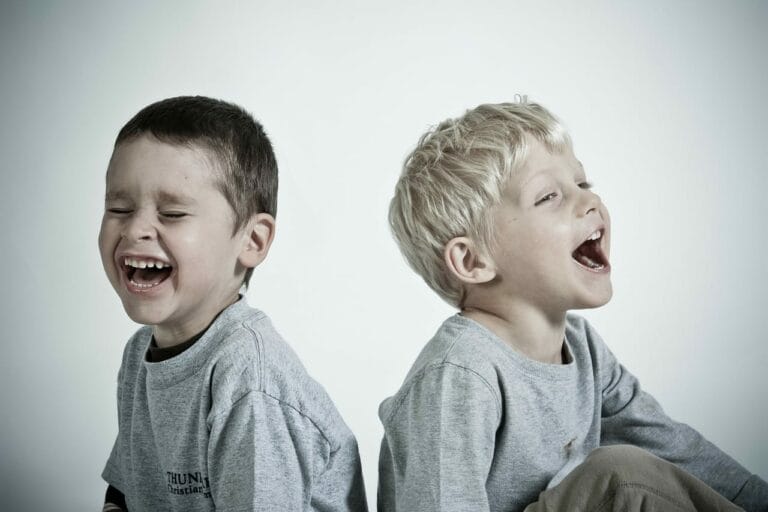 Two children laughing and listening to each-other