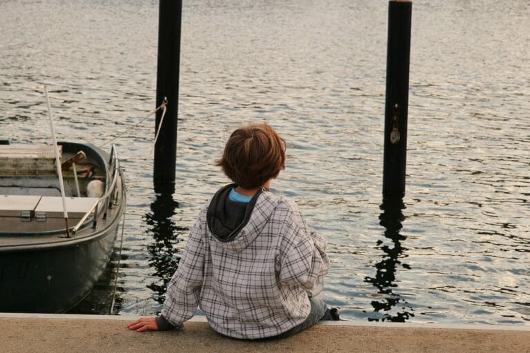 child with Reactive Attachment Disorder sitting by a lake