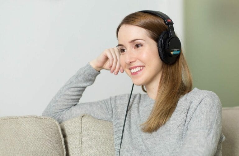 A speech language pathologist therapist wearing a headset and sitting on a couch