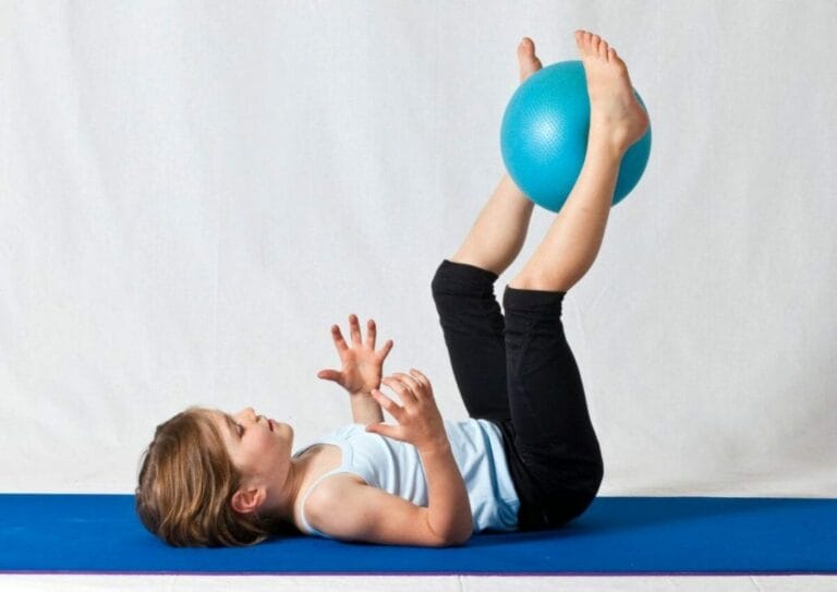 child on back with stress ball between legs