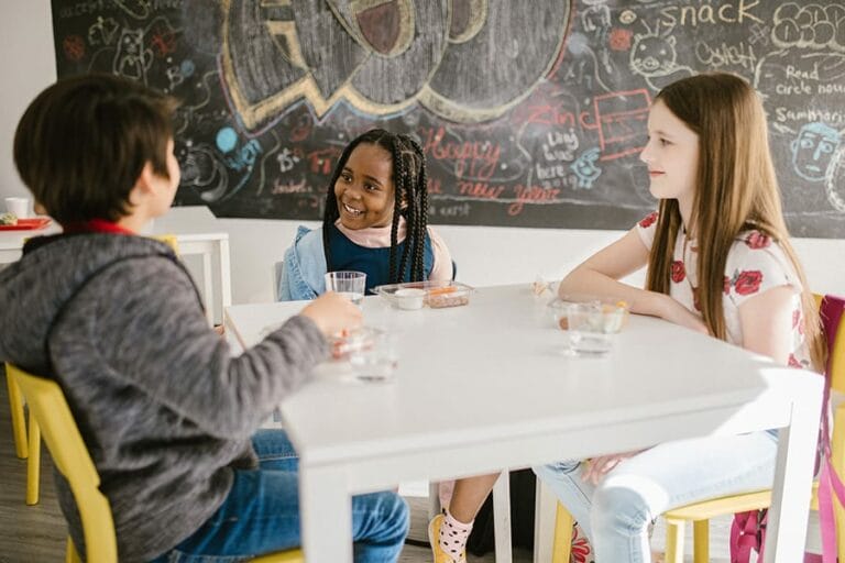 children talking at schoolroom table