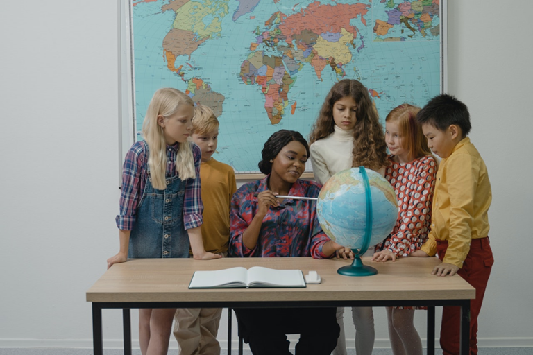 sped teacher looking at globe with students